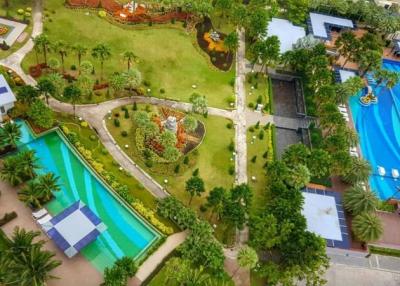 Aerial view of a luxurious residential complex with lush gardens and multiple swimming pools