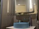 Modern bathroom interior with illuminated mirror and blue basin