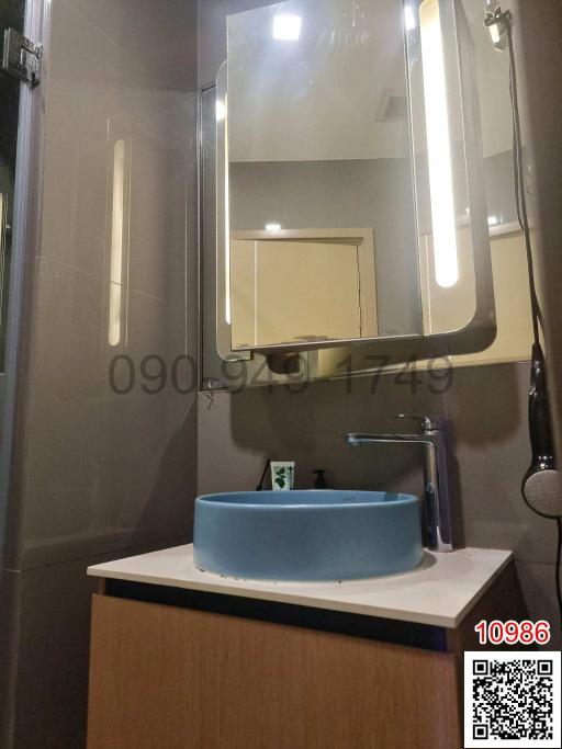 Modern bathroom interior with illuminated mirror and blue basin