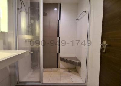 Modern bathroom with glass shower enclosure and wooden door