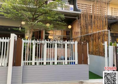 Modern residential building exterior with a bamboo facade and grey fence