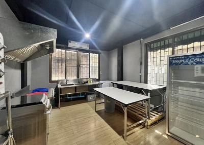 Spacious industrial-style kitchen with stainless steel counters and commercial-grade appliances