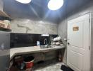 Compact kitchen with concrete countertops and overhead lighting