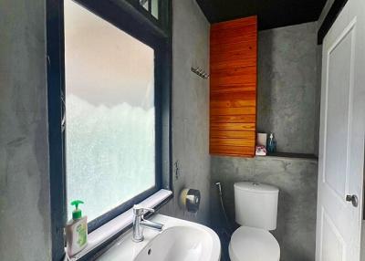 Modern bathroom with frosted glass window and concrete walls