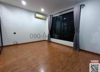 Spacious unfurnished bedroom with hardwood flooring and large window