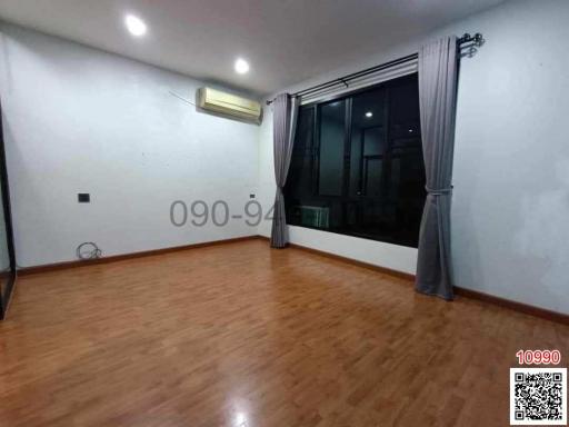 Spacious unfurnished bedroom with hardwood flooring and large window