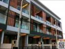 Modern multi-story residential building with balconies and wooden accents