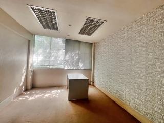 Empty office space with large window and textured wall