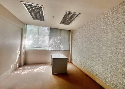 Empty office space with large window and textured wall