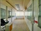 Spacious empty office space with large windows and glass partition