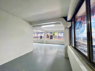Spacious empty room with large windows and concrete flooring