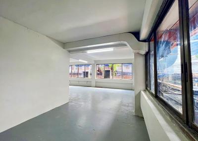 Spacious empty room with large windows and concrete flooring