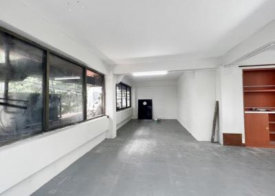 Spacious empty room with large windows and built-in shelves