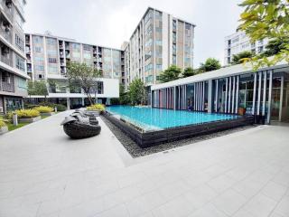 Modern residential building complex with swimming pool and lounging area