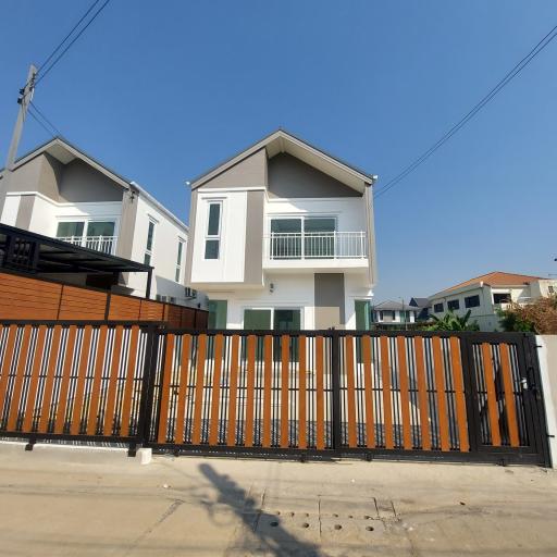 Modern two-story residential house with balcony and gated fence