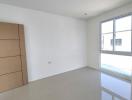 Spacious and bright empty bedroom with large window and glossy tiled flooring