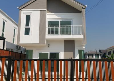 Modern two-story house with a balcony and fencing