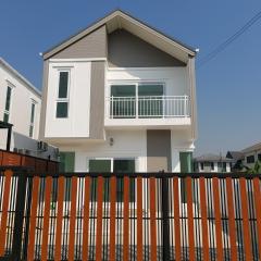 Modern two-story house with a balcony and fencing