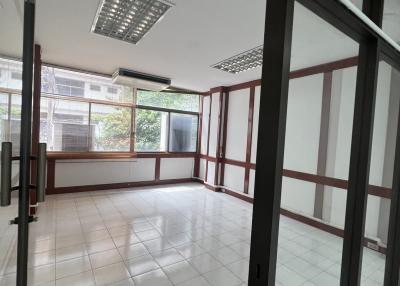 Spacious and well-lit office space with large windows and tiled flooring