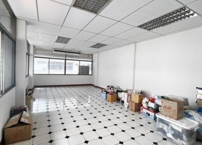 Spacious empty room with tiled flooring and drop ceiling