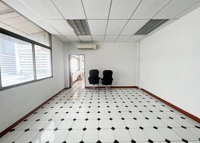 Spacious empty office with large windows and tiled flooring