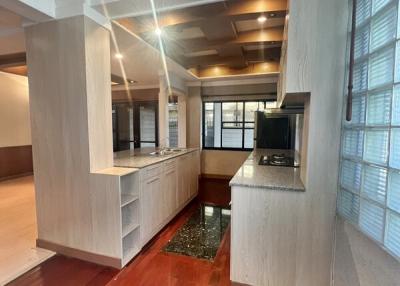 Modern kitchen interior with red tiled flooring and wooden cabinetry