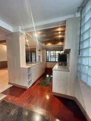 Modern kitchen interior with red tiled flooring and wooden cabinetry