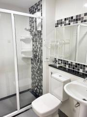 Modern white and black tiled bathroom with shower cabin