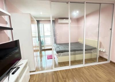 Modern bedroom with large mirrored wardrobe and wooden flooring