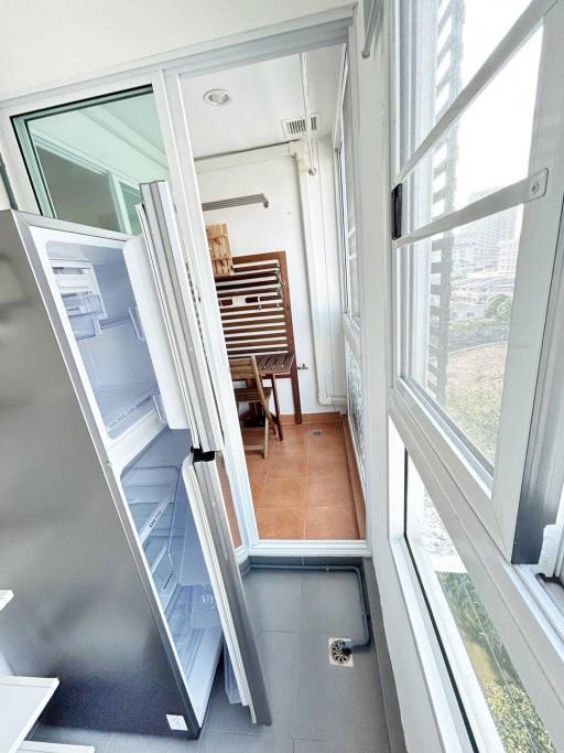 Enclosed balcony with tile flooring and seating area