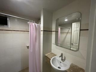 Bright bathroom with tiled walls, sink, and mirror