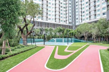 Well-maintained common area with green space, running track, and basketball court in a residential apartment complex