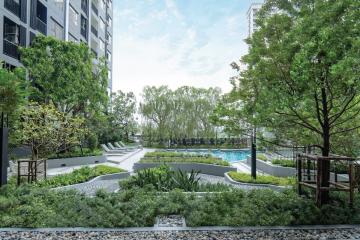 Tranquil outdoor common space with lush greenery and swimming pool in a residential building