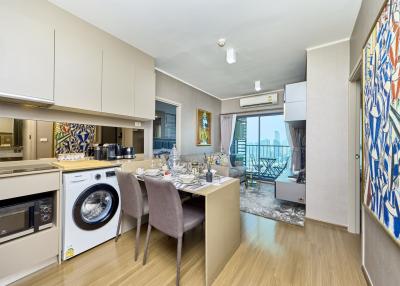 Modern open-plan kitchen with dining area and balcony access in a contemporary apartment