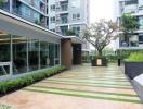 Exterior view of a modern apartment complex with landscaped entrance