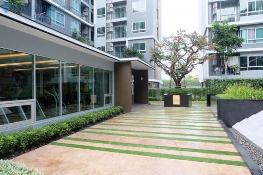 Exterior view of a modern apartment complex with landscaped entrance