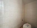 Compact bathroom with tiled walls