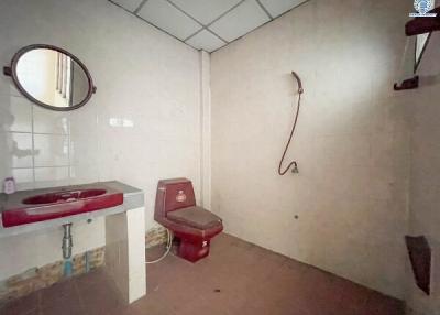 Spacious bathroom with a red sink and toilet