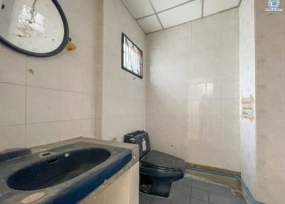 Spacious bathroom with sink, toilet, and tiled walls