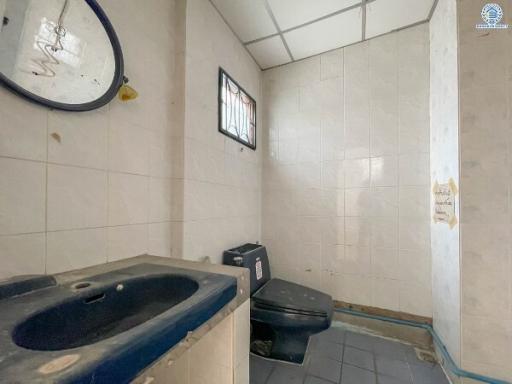 Spacious bathroom with sink, toilet, and tiled walls