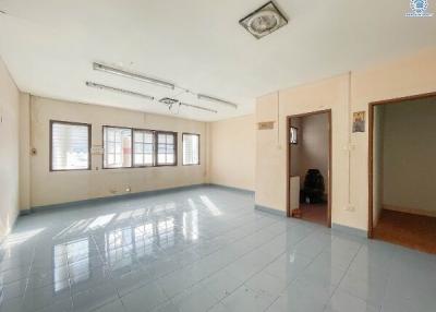 Spacious and well-lit empty room with tiled flooring and multiple windows