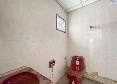 Compact bathroom with basic fixtures and wall tiles