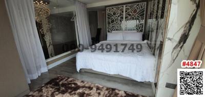 Elegant bedroom with a queen-sized bed, mirrored wardrobe, and decorative wall panels