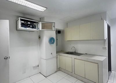 Compact kitchen with white cabinetry and tiled flooring