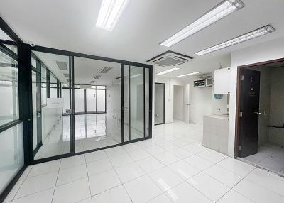 Spacious commercial office interior with glass partitions and tiled flooring