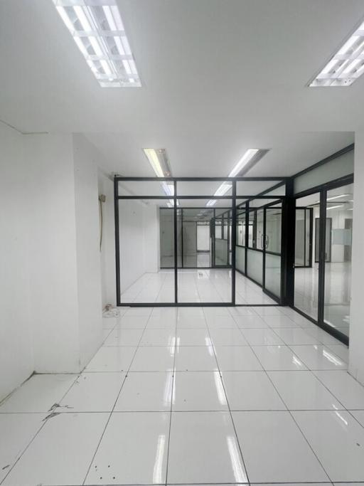 Spacious commercial building interior with glass partitions and fluorescent lighting