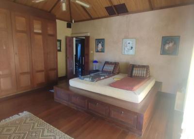 Spacious bedroom with wooden furniture and high ceiling
