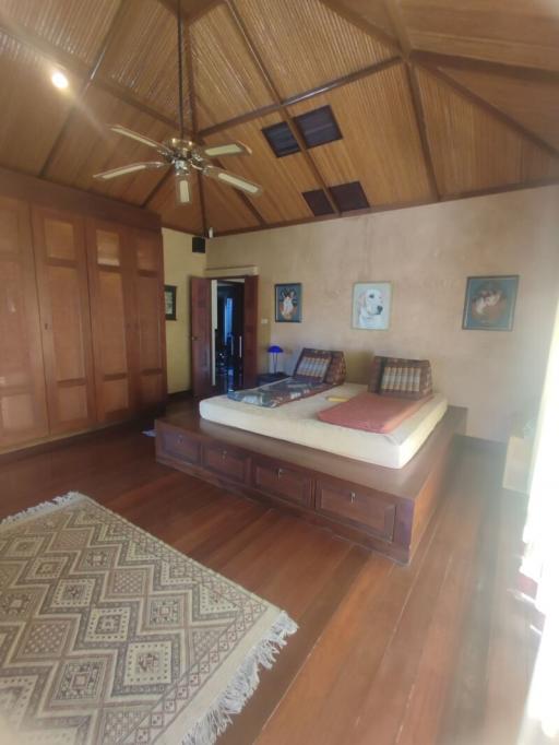 Spacious bedroom with wooden furniture and high ceiling