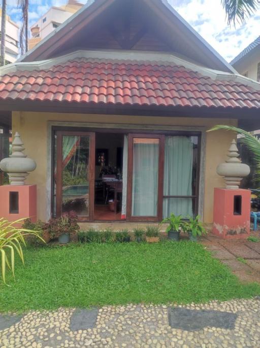 Cozy suburban house with terracotta roof and lush green lawn