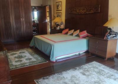 Spacious bedroom with hardwood floors and traditional decor